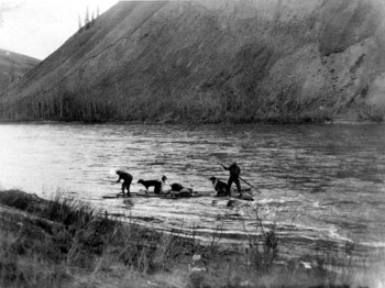 “Another mode of northern travel: not so *hot* for speed but always cheap enough. Jinks and Pete crossing on a raft. May 1930”
