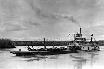 “Some local views in and around Mayo. Yukon Territory. 1932. The Steamer Keno arrives with barge of oil.”
