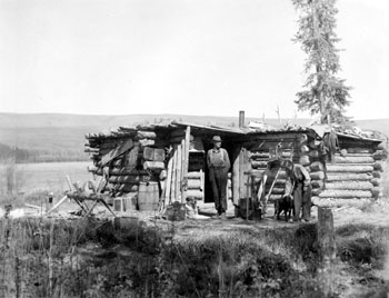“Had a pleasant stay here on our boat trip down the Stewart. Burnell's cabin June 1937” Ed Burnell and Mary Tidd standing in front of Burnell′s trapping cabin on the Stewart River. 