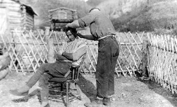 “Our tonsorial emporium in the north.” Claude gets a trim at New Rampart House, ca. 1920.