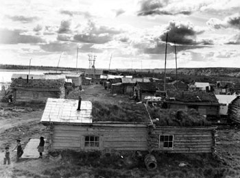 Panorama of Old Crow. Some of the cabin roofs have been covered with flattened gas cans. 1946