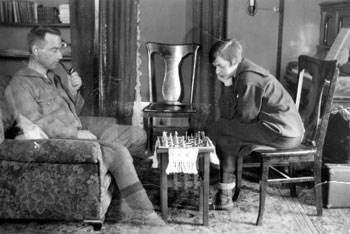Mary et Claude jouant aux échecs dans leur maison de Dawson. Dans son commentaire incrit à l'arrière de la photo, Mary déplore le fait que Claude ait insisté pour qu'elle porte cet inélégant caleçon long. 