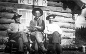 Claude (au centre, Robert McCleary (à gauche) et F.W. Miller (à droite) devant le poste de la GRC à Teslin. 