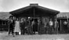 Un groupe de résidents de Ross River devant le poste de la Taylor and Drury. Claude Tidd se trouve à l'extrême gauche, Pete Picard est à sa gauche et Del Van Gorder est le sixième à partir de gauche. 1923
